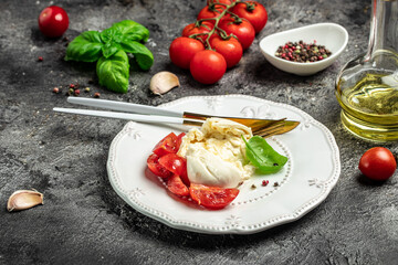 fresh soft white burrata cheese ball made from mozzarella and cream from Apulia, Italian Mediterranean cuisine, Food recipe background. Close up