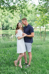 Fototapeta premium full length of happy young couple in summer standing in park, embracing, happy people