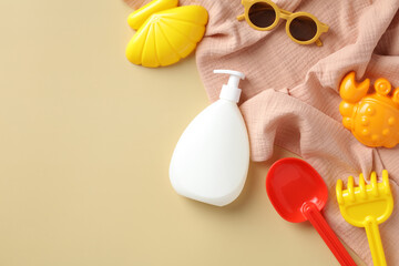 Sunscreen cream lotion bottle, sunglasses, sand molds, towel on beige background. Sun protection cosmetics for kids concept.