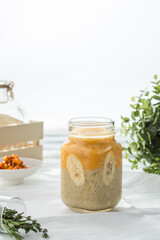 Banana smoothie in mason jars for breakfast on white wooden background