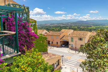 Scenic view from a terrace with purple bougainvillea flowers of the countryside and the hills of...