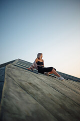 Young woman posing in the roof at sunset, freedom city atmosphere. People, lifestyle, relaxation concept.