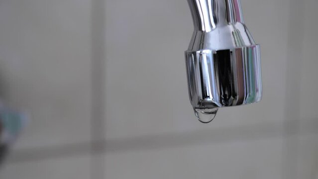 Dripping faucet, waste of water. Slow motion