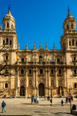 Photograph of the Facade of the Cathedral of Jaén at noon with people commuting