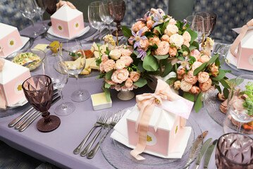 Festive served table with flowers and decor in pastel colors for guests on a plate
