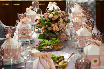 Festive served table with flowers and decor in pastel colors for guests on a plate