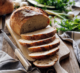 Sliced traditional artisan, sourdough bread on a wooden board, close-up view
