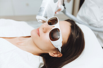 Cosmetology. Beautiful woman getting laser hair removal procedure in beauty salon. Close-up of a...