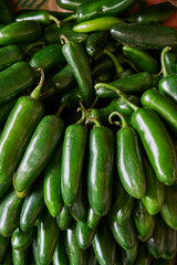 Green chilies placed on a shelf for sale within a market
