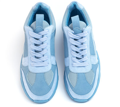 Light blue sneakers on a white background. Sports shoes top view
