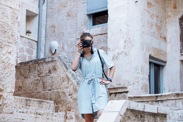 Attractive blonde young woman taking pictures with camera in Italian European city, young architect on vacations 