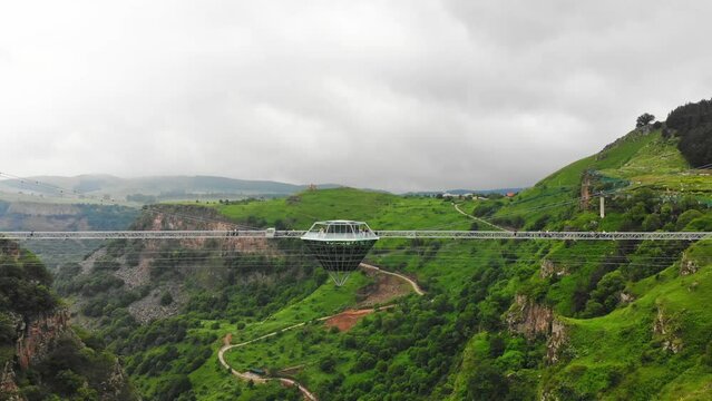 Dashbashi, Georgia - 19th june, 2022: Aerial fly over Diamond shape platform on glass bridge over scenic dashbashi valley in Georgia countryside. Famous modern bridge over valley in caucasus