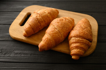 Fresh croissants on a wooden background.
