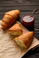 Tasty and delicious croissants with jam on a wooden table