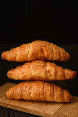 Fresh croissants on a wooden background.