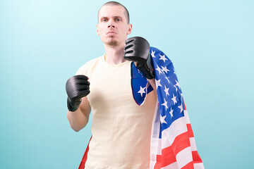 A confident MMA fighter in black gloves and a USA flag ready to fight on a blue background....
