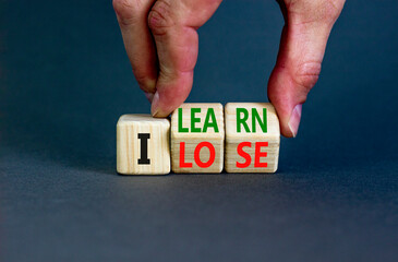 I learn or lose symbol. Concept words I learn and I lose on wooden cubes. Businessman hand. Beautiful grey table grey background. Business and i learn or lose concept. Copy space.