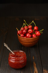 Homemade cherry jam on a rustic background
