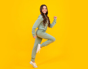 Fototapeta na wymiar Beautiful teenager child girl in a sports suit, tracksuits. The girl in street sport clothing. Fashion and style, trends. Mockup and copyspace.