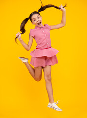 Fototapeta na wymiar Full length overjoyed teenager kid girl 12 13 14 year jumping old isolated on yellow background studio. Funny jump. Child in summer movement dress.