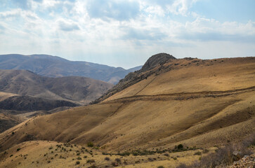 View of hilly relief, mountain slopes with sparse vegetation of autumn Caucasus mountains in Armenia