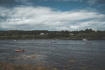 Small boats on lake, cloudy blue sky
