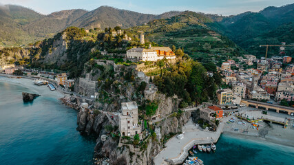 Aerial view of Monterosso and landscape of Cinque Terre,Italy.UNESCO Heritage Site.Picturesque colorful coastal village located on hills.Summer holiday,travel background.Italian Riviera.Torre Aurora