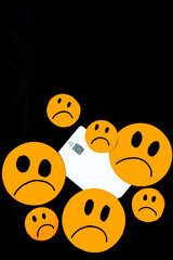 Vertical illustration of discontent, scam, disappointment with bank credit cards represented with sad orange emoticons and a bank card on a black background