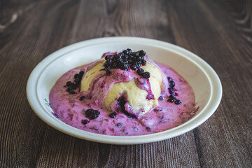 Homemade blueberry dumplings with cream,Czech sweet dessert typical in the mountains.Fresh blueberries. Sweet fruit dumplings.Czech cuisine.Food in ceramic vintage bowl on wooden table