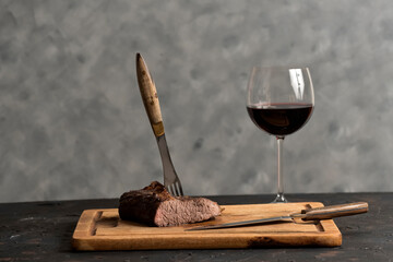 Roasted beef ribs with a glass of red wine presented on the table, traditional Argentine cuisine,...