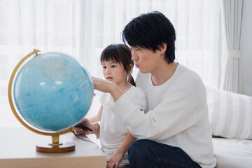 パパと地球儀を使って勉強する家族