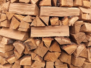Lots of chopped firewood on a pile close up. Harvesting firewood for the winter. Dry firewood for a fireplace.wall from firewood
