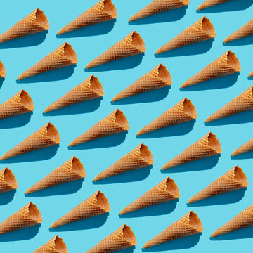 Empty wafer ice cream cones continuous pattern on blue background .Isoclate, hard light
