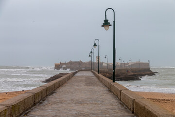 Stone path that leads to the castle of San Sebastián from the beach of La Caleta, in Cádiz, Spain