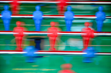 Table soccer with red and blue players in game motion