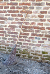 Broom on a brick wall