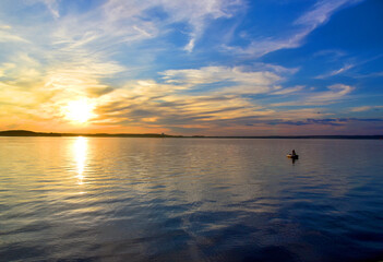 Fishermen boat on lake. Fishing for river fish from a motor boat using a fishing rod or spinning rod. Sports fishing on water. Rest in wild. Fishing boat with a fisherman on lake while catching fish.