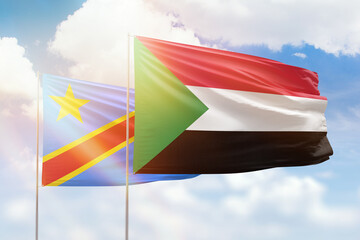 Sunny blue sky and flags of sudan and dr congo