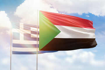 Sunny blue sky and flags of sudan and greece