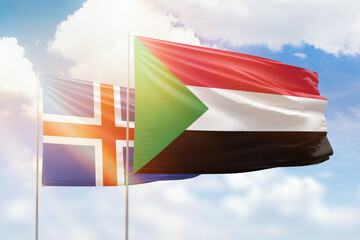 Sunny blue sky and flags of sudan and iceland