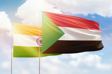 Sunny blue sky and flags of sudan and india