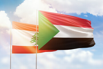 Sunny blue sky and flags of sudan and lebanon