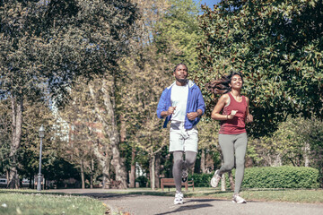 multiethnic couple running in park