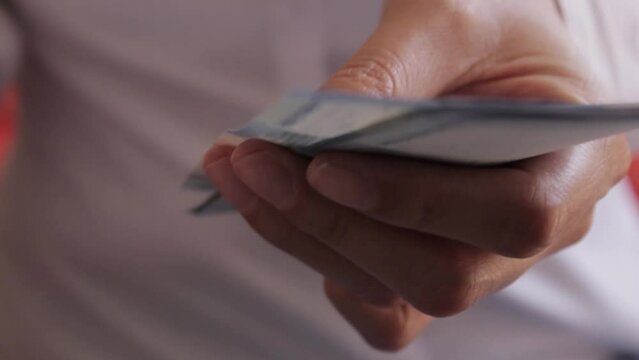 Persona con camisa blanca contando billetes de quinientos pesos mexicanos