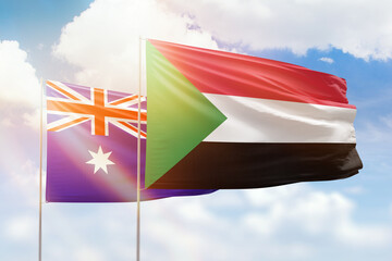 Sunny blue sky and flags of sudan and australia