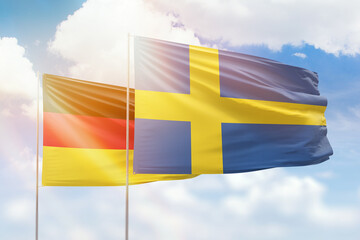 Sunny blue sky and flags of sweden and germany