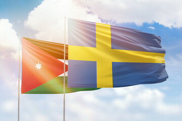 Sunny blue sky and flags of sweden and jordan