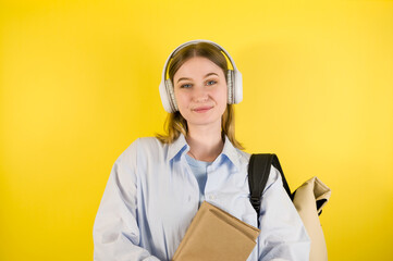 Happy female student listens to music or podcast holding laptop. High school or university education.Programming courses concept
