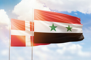 Sunny blue sky and flags of syria and denmark