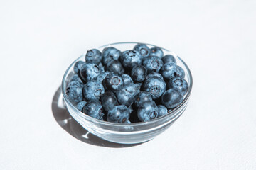 Blue blueberry in bowl - berries on white, organic summer food